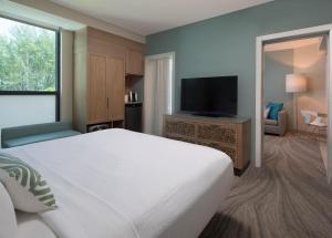 a bedroom with a large bed and a flat screen tv at Zota Beach Resort in Longboat Key