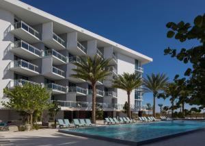 an apartment building with a swimming pool and palm trees at Zota Beach Resort in Longboat Key