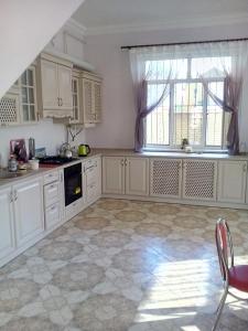 une cuisine avec des placards blancs et une grande fenêtre dans l'établissement Дом на берегу Черного Моря, à Zatoka