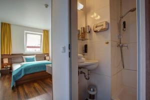 a small bathroom with a bed and a sink at North-Hotel in Hamburg