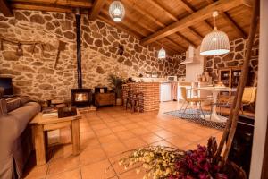 a large living room with a fireplace and a kitchen at El Pajar de Tío Mariano in Solana de ávila