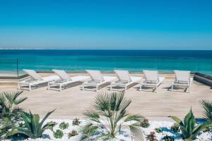a row of lounge chairs on the beach at Iberostar Selection Kuriat Palace in Monastir