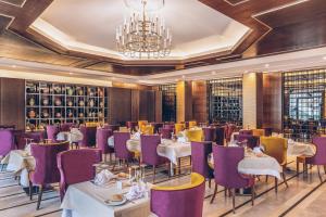 a restaurant with tables and chairs and a chandelier at Iberostar Selection Kuriat Palace in Monastir