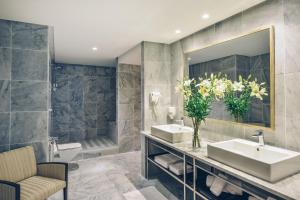 a bathroom with two sinks and a tub and a mirror at Iberostar Selection Kuriat Palace in Monastir