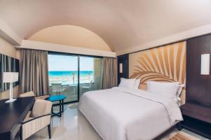 a bedroom with a bed and a desk and a window at Iberostar Selection Kuriat Palace in Monastir