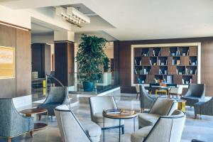 a lobby with chairs and tables and bookshelves at Iberostar Selection Kuriat Palace in Monastir
