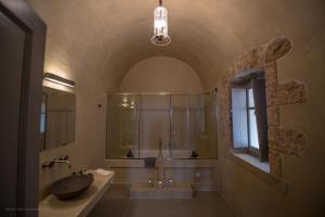 a bathroom with a sink and a glass shower at IPPOLA BOUTIQUE HOTEL in Érimos