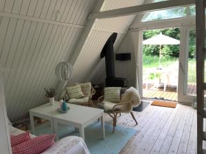 sala de estar con mesa, sillas y chimenea en The Doll House - Adults Only en Ebeltoft