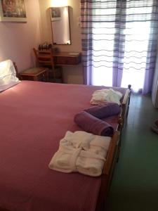 een slaapkamer met een bed met handdoeken erop bij Nana Hotel in Kamena Vourla
