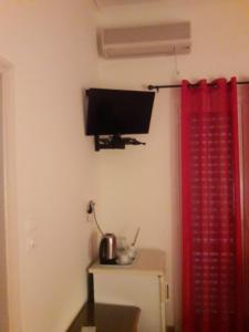a room with a television and a red curtain at Nana Hotel in Kamena Vourla