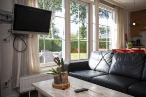 a living room with a couch and a flat screen tv at Bunckman 10 pers. bungalow in Voorthuizen