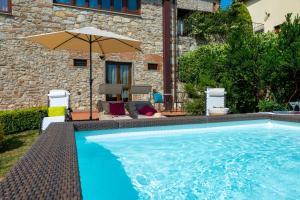 una piscina con sombrilla y sillas en Villa San Giorgio en Montemurlo