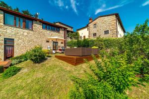 un patio trasero con una casa de piedra con jardín en Villa San Giorgio en Montemurlo