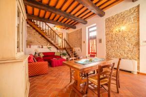 sala de estar con mesa de madera y sofá rojo en Villa San Giorgio en Montemurlo