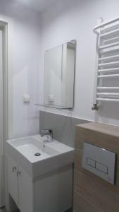 a white bathroom with a sink and a mirror at Corner in Mielno