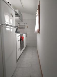Il comprend une cuisine dotée d'un réfrigérateur blanc et de carrelage blanc. dans l'établissement Casa Mar.e, à Grottammare