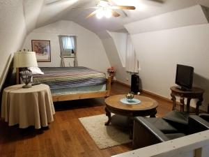a bedroom with a bed and a table and a couch at Almond Cabin in Fredericksburg