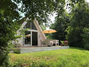 una pequeña casa con sombrilla y sillas en el patio en The Doll House - Adults Only en Ebeltoft
