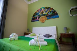 a bedroom with a bed with green sheets and towels at Sicily Luxury B&B in Catania