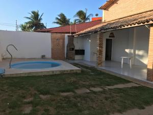 un patio trasero con piscina y una casa en Chalé encantador en Barra de São Miguel