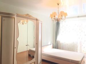 キーロフにあるApartment on Preobrazhenskayaのベッドルーム(鏡、シャンデリア付)