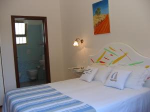 トッレ・スーダにあるIl Gabbianoのベッドルーム(白いベッド、白い枕付)