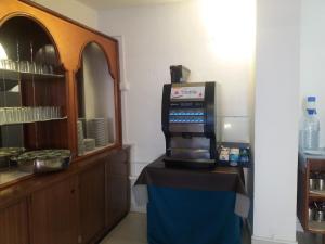 a kitchen with a refrigerator, sink and a television at Hotel Riomar in Lagos