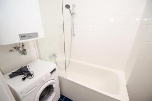 ein Bad mit einer Waschmaschine und einer Dusche in der Unterkunft Apartment CityXpress TOP 7 in Zell am See