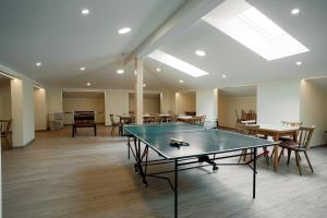 a ping pong table in a room with tables and chairs at Mühlbacherhof in Rennweg