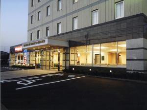 un aparcamiento vacío frente a un edificio en Kuretake-Inn Hamamatsu Nishi I.C. en Hamamatsu
