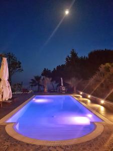 una gran piscina azul por la noche con luna en Casa Masaria, en Lipari