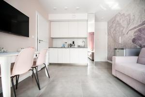 uma cozinha e sala de estar com uma mesa e um sofá em Amelia Suite em Gdansk
