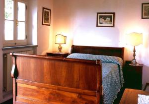 um quarto com uma cama de madeira e 2 candeeiros em Dependance 2 pax em Cortona