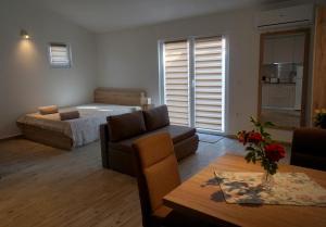 a bedroom with a bed and a couch and a table at Apartments Sanja in Jezera