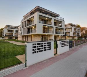 an apartment building with a fence in front of it at Balaton Exclusive Apartman in Csopak