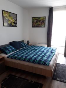 sypialnia z łóżkiem z niebieską kołdrą w obiekcie Balaton Exclusive Apartman w mieście Csopak +25 zdjęć