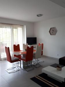 salon ze stołem i czerwonymi krzesłami w obiekcie Balaton Exclusive Apartman w mieście Csopak