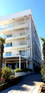 ein großes weißes Gebäude mit Palmen davor in der Unterkunft Hotel Strand a frontemare in Lido di Jesolo