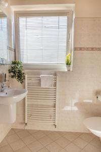 a bathroom with a sink and a toilet and a window at Hotel Kanarek in Prague