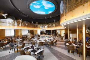 a restaurant with tables and chairs and a round ceiling at Hotel Le Negresco in Nice