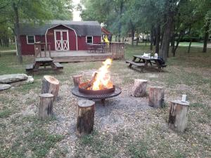 una hoguera frente a un granero rojo en Almond Cabin en Fredericksburg