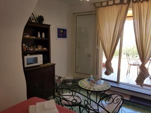 a living room with a table and chairs and a window at B&B nonnAngela in Maratea