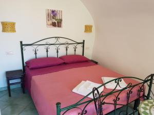 um quarto com uma cama com uma colcha vermelha em B&B nonnAngela em Maratea
