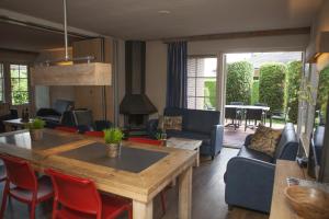 a living room with a table and chairs at Ganzebeek 14 pers. bungalow in Voorthuizen