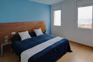 サンタ・スサナにあるApartamentos Bon Repósの青いベッドルーム(ベッド1台、窓2つ付)