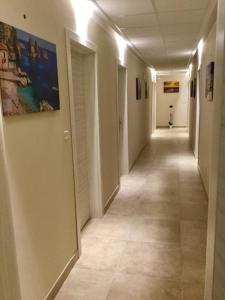 a hallway with a long corridor with white walls at La Giummara Rooms in Salemi