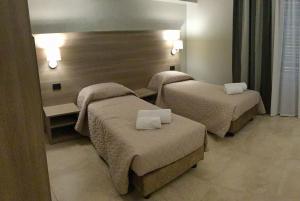 a hotel room with three beds in a room at La Giummara Rooms in Salemi