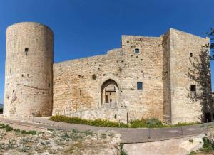 a large stone building with two towers at La Giummara Rooms in Salemi