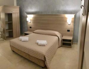 a bedroom with a bed with two towels on it at La Giummara Rooms in Salemi