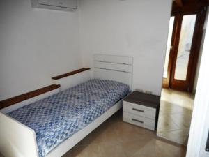 Habitación pequeña con cama y mesita de noche en Giulia, en Gaeta